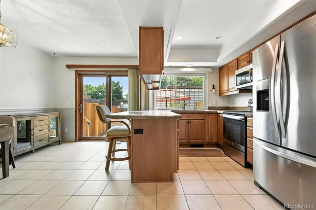 a kitchen with stainless steel appliances granite countertop a refrigerator and a stove top oven