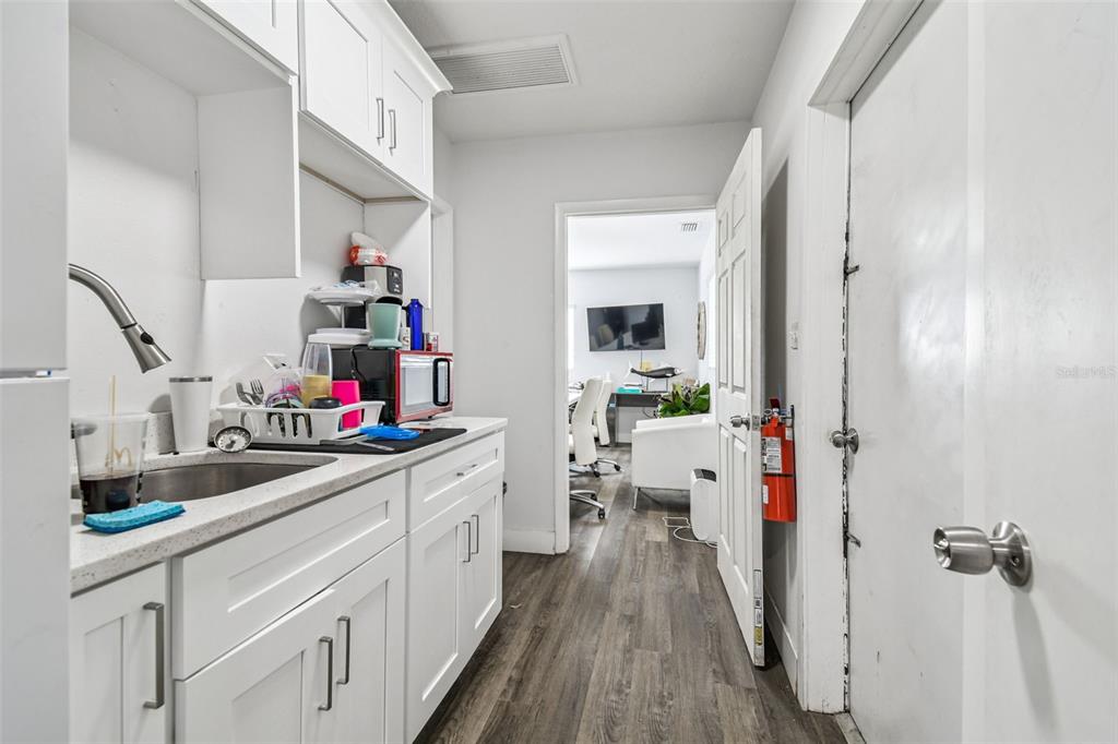 6010 Wall Street Port Richey, FL 34668 - Photo 36 of 43 a kitchen with white cabinets and wooden floor