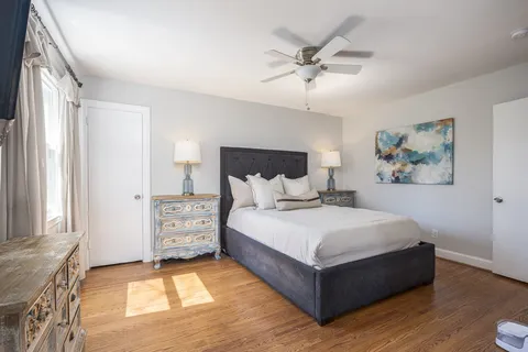 a spacious bedroom with a bed and a ceiling fan
