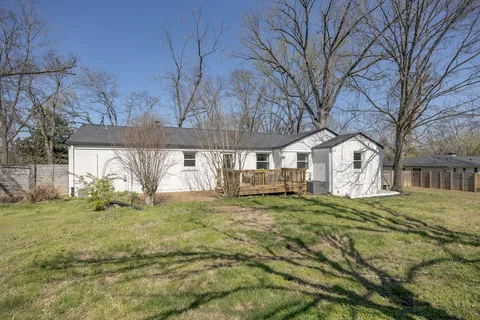 a view of a yard with a house and a large tree