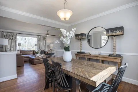a view of a dining room with furniture a chandelier and wooden floor