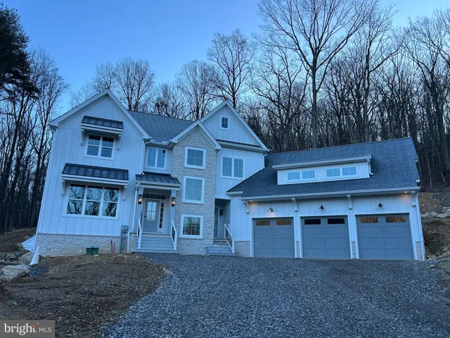 a view of a house with a yard and large tree