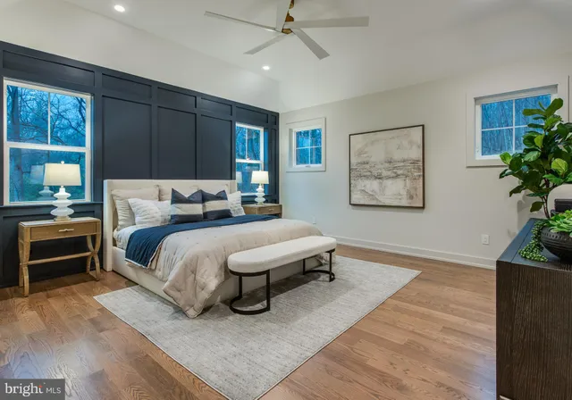 a bedroom with a bed lamp and paintings on the wall
