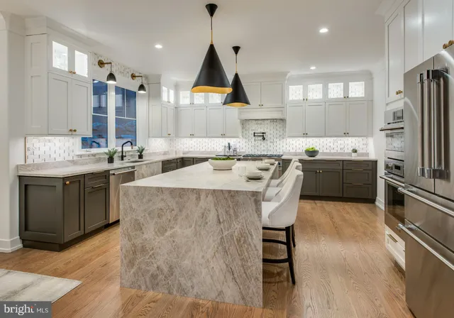 a kitchen with stainless steel appliances granite countertop a sink a stove and a refrigerator