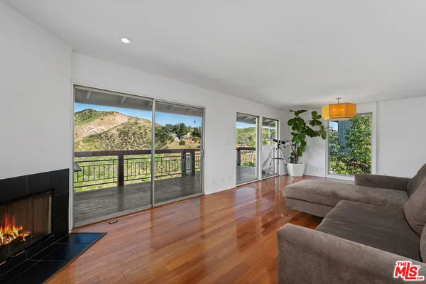a living room with hardwood floor and a balcony