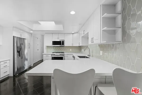 a kitchen with white cabinets and white appliances