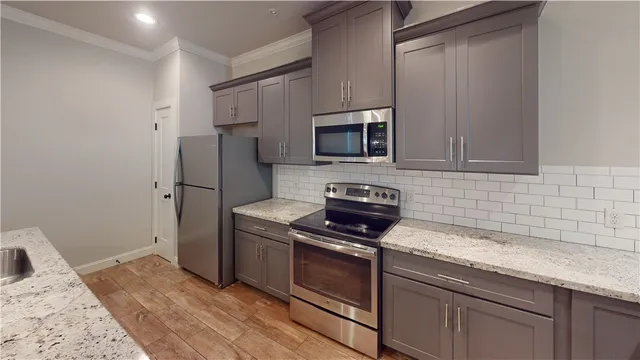 a kitchen with granite countertop cabinets stainless steel appliances and wooden floor