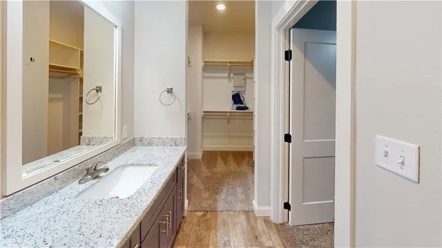 a bathroom with a granite countertop double vanity sink and mirror