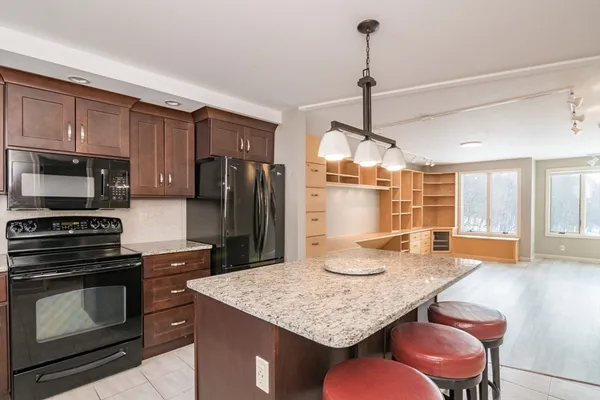 a kitchen with stainless steel appliances granite countertop a stove refrigerator and microwave