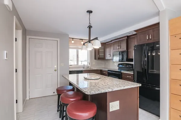 a kitchen with stainless steel appliances granite countertop a sink stove and refrigerator