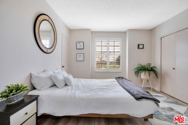 a bedroom with a bed and a potted plant
