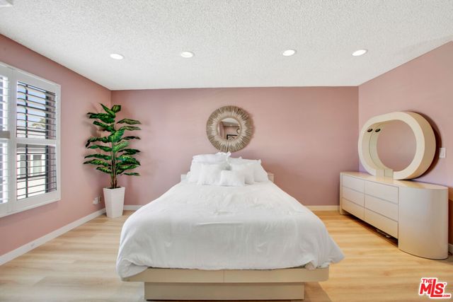 a bedroom with a bed and a potted plant