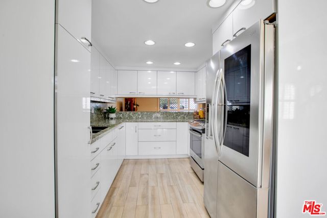 a kitchen with white cabinets and stainless steel appliances