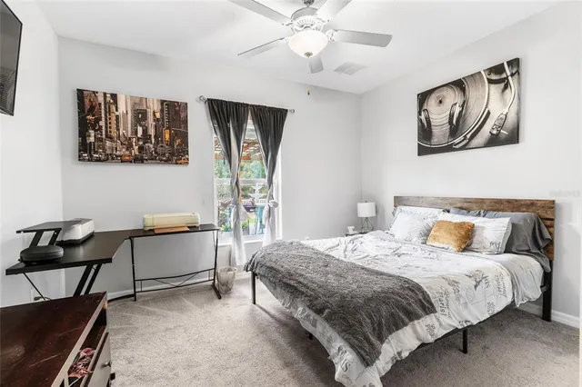 a bedroom with a bed and painting on the wall