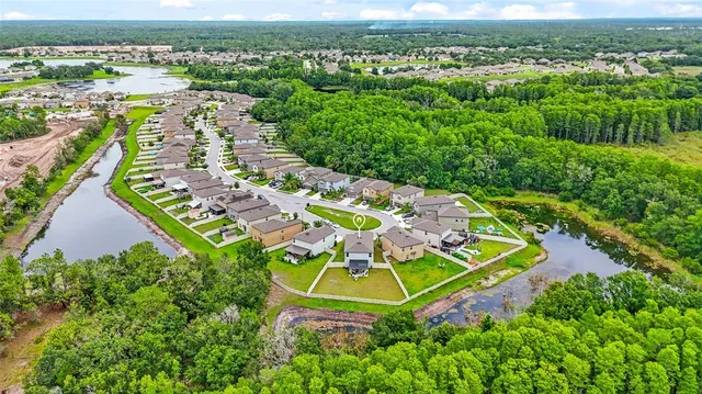 an aerial view of residential houses with outdoor space and trees