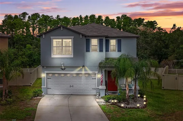 a open kitchen with stainless steel appliances granite countertop a stove top oven a refrigerator a sink and a dining table with white cabinets