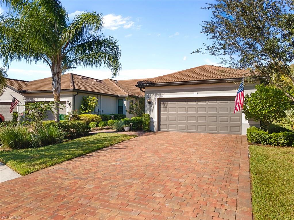 5845 Mayflower Way Ave Maria, FL 34142 - Photo 2 of 48 a front view of a house with a garden