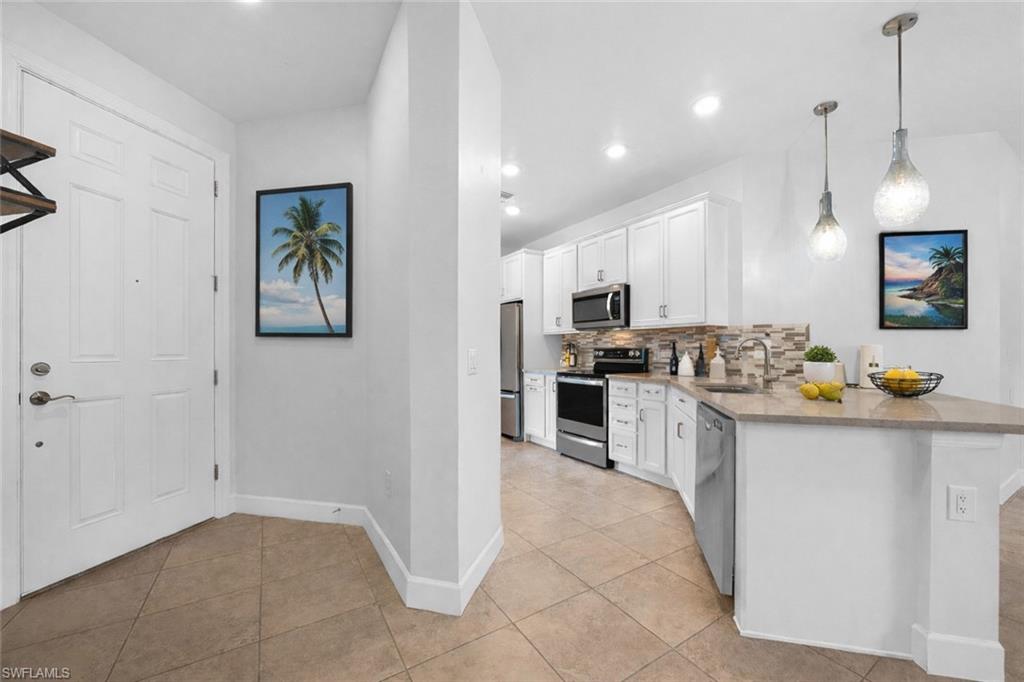 5845 Mayflower Way Ave Maria, FL 34142 - Photo 5 of 48 a kitchen with stainless steel appliances a refrigerator a stove a sink a oven a dining table and chairs