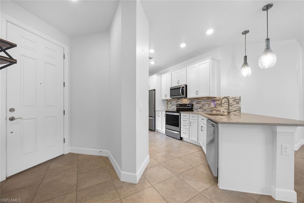 5845 Mayflower Way Ave Maria, FL 34142 - Photo 6 of 48 a kitchen with stainless steel appliances a refrigerator sink and stove top oven