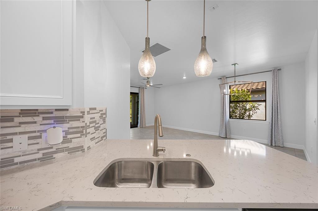5845 Mayflower Way Ave Maria, FL 34142 - Photo 10 of 48 a kitchen with a sink and chandelier