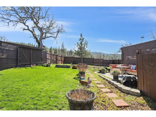 a view of a patio with table and chairs potted plants and floor to ceiling window