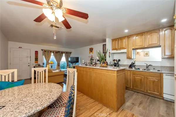 a kitchen with stainless steel appliances granite countertop a sink dishwasher stove refrigerator dining table and chairs
