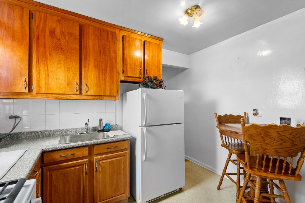 60-11 Broadway, Unit 3C Queens, NY 11377 - Photo 11 of 18 a kitchen with stainless steel appliances granite countertop a refrigerator and a stove top oven