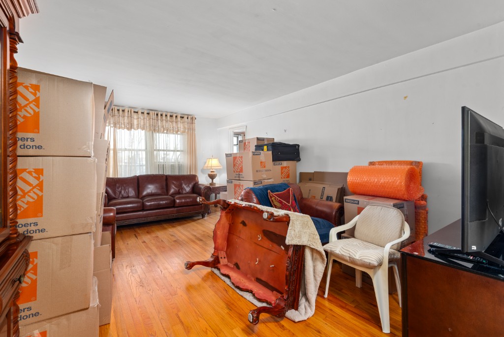 60-11 Broadway, Unit 3C Queens, NY 11377 - Photo 12 of 18 a living room with furniture and a flat screen tv