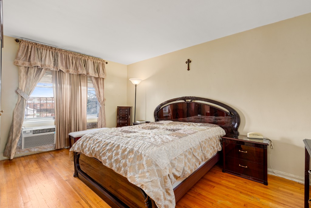 60-11 Broadway, Unit 3C Queens, NY 11377 - Photo 4 of 18 a bedroom with a bed and a window