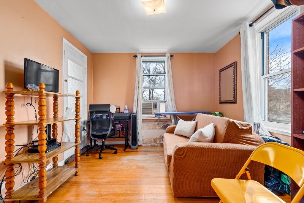 60-11 Broadway, Unit 3C Queens, NY 11377 - Photo 7 of 18 a living room with furniture and a flat screen tv