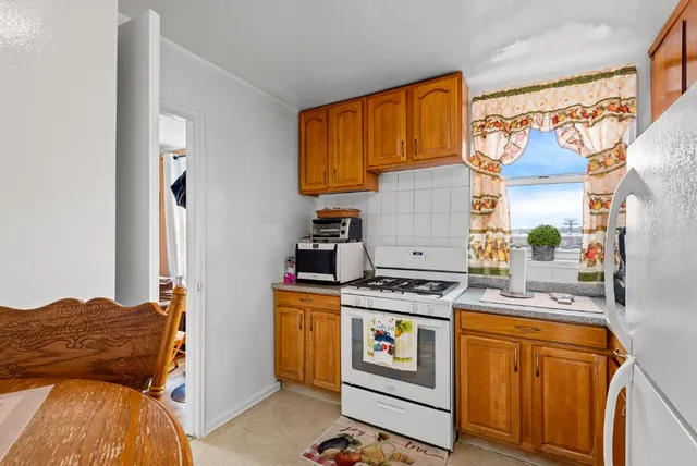 a kitchen with stainless steel appliances a stove a sink and a refrigerator with wooden cabinets