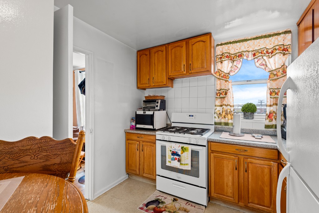 60-11 Broadway, Unit 3C Queens, NY 11377 - Photo 9 of 18 a bedroom with a bed and a stove top oven