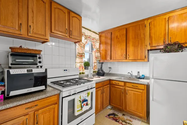 a kitchen with stainless steel appliances granite countertop a refrigerator and a stove top oven