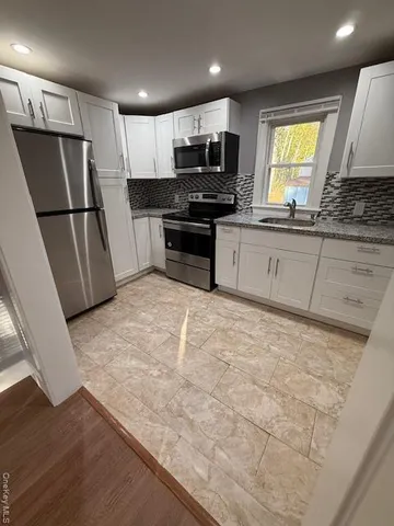a kitchen with granite countertop a refrigerator and a sink