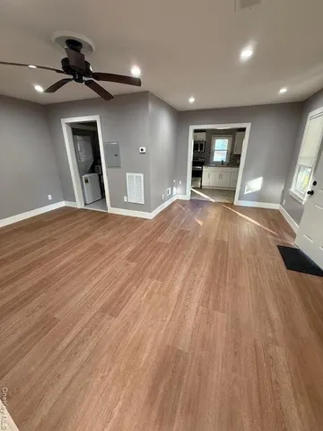 a view of empty room with wooden floor