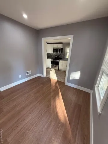 a view of a hallway with wooden floor fireplace and a window