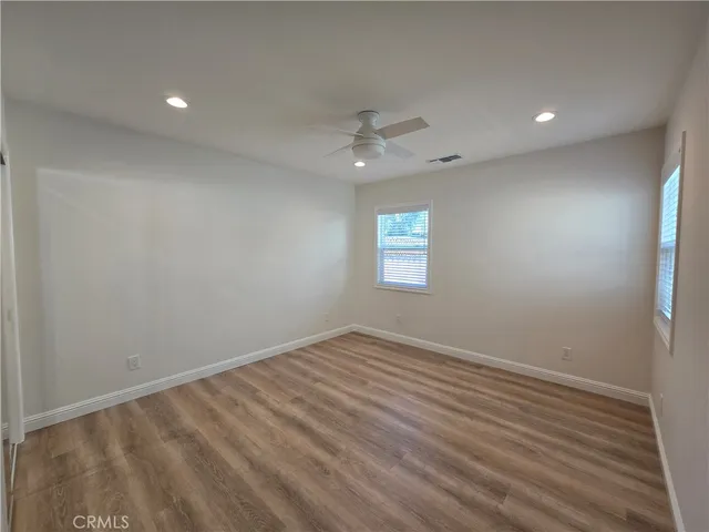 an empty room with a window and a ceiling fan