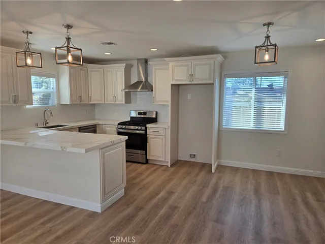 a kitchen with kitchen island wooden floors appliances and cabinets