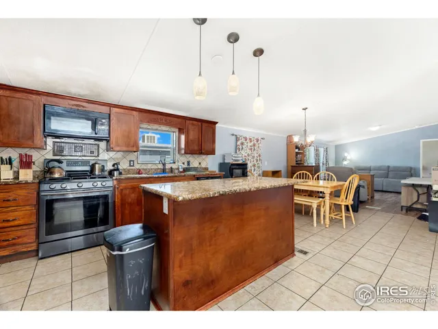 a kitchen with stainless steel appliances kitchen island granite countertop a stove a sink and a refrigerator