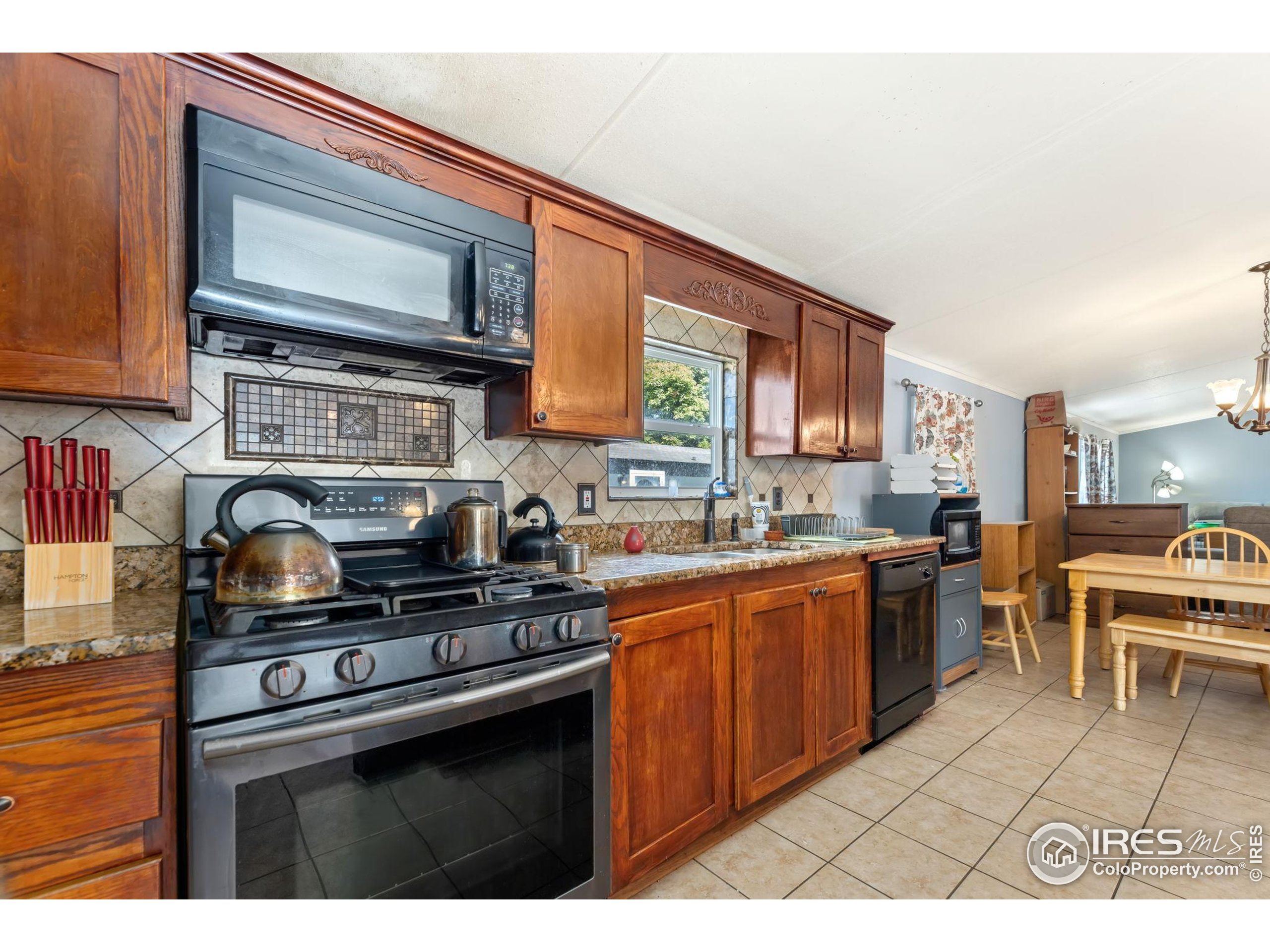 218 Grape Street, Unit 29 Hudson, CO 80642 - Photo 13 of 26 a kitchen with stainless steel appliances a stove a sink cabinets and a microwave
