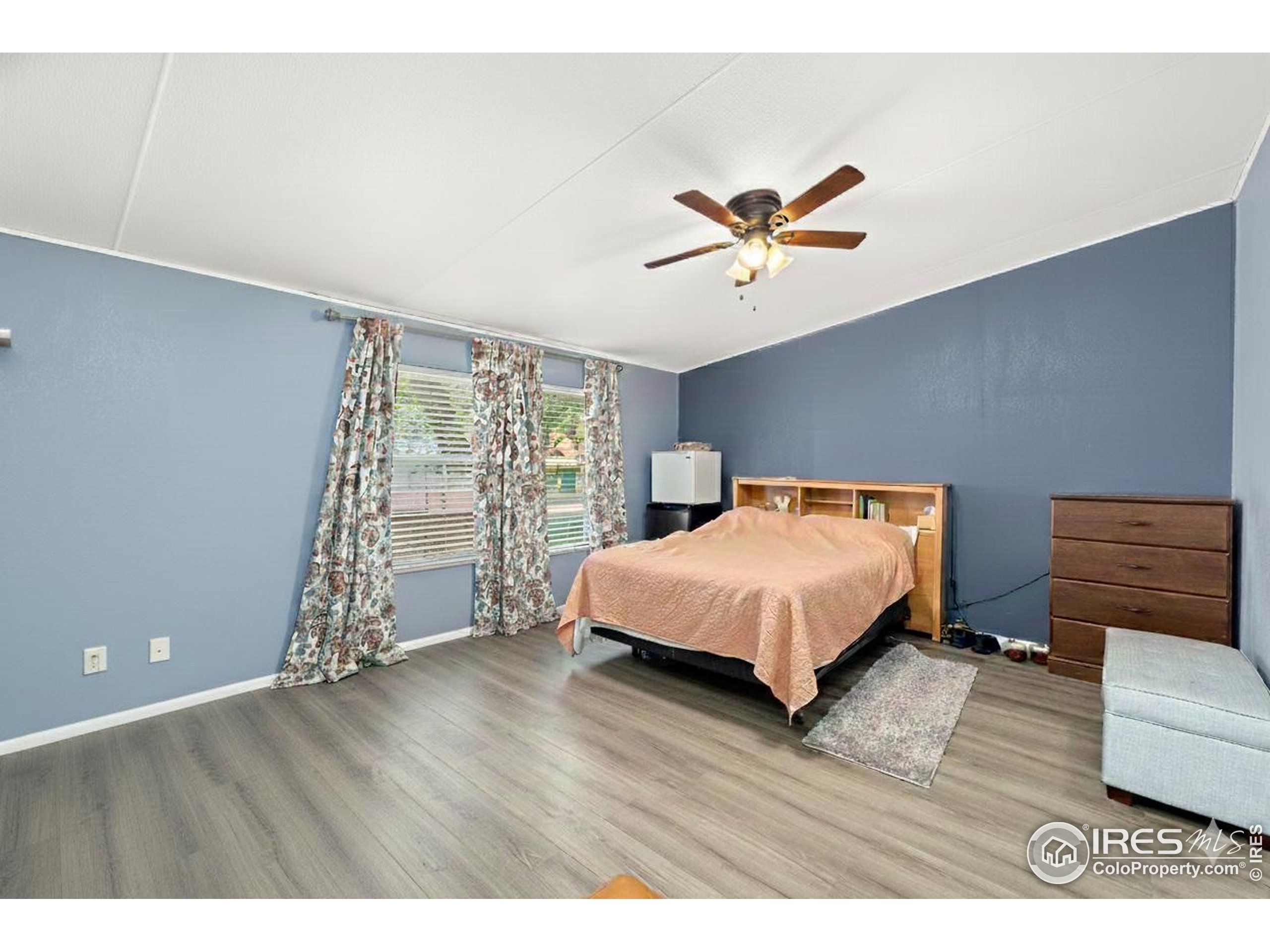 218 Grape Street, Unit 29 Hudson, CO 80642 - Photo 22 of 26 a spacious bedroom with a bed and a book shelf