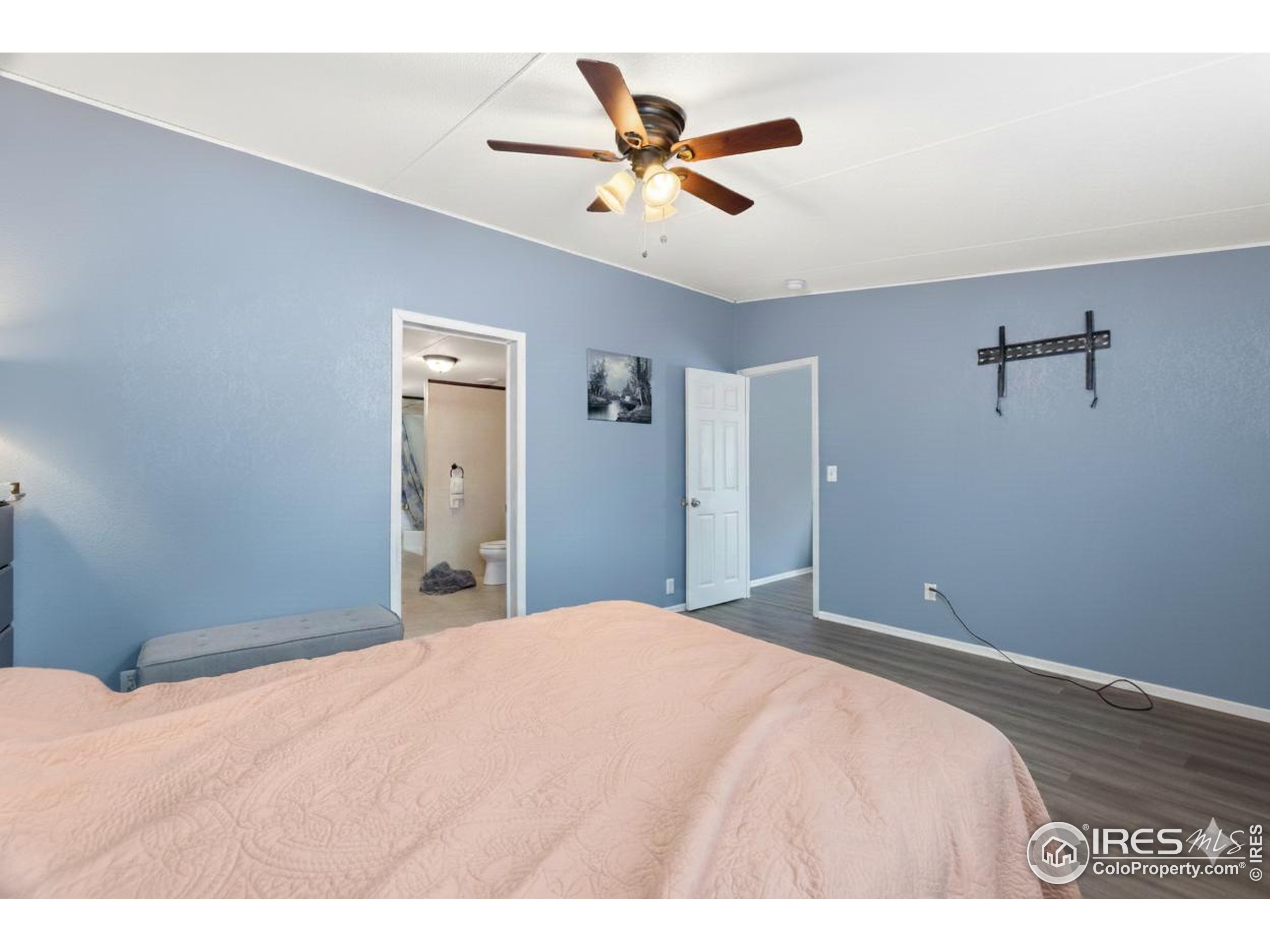 218 Grape Street, Unit 29 Hudson, CO 80642 - Photo 25 of 26 a bedroom with a bed and a chandelier