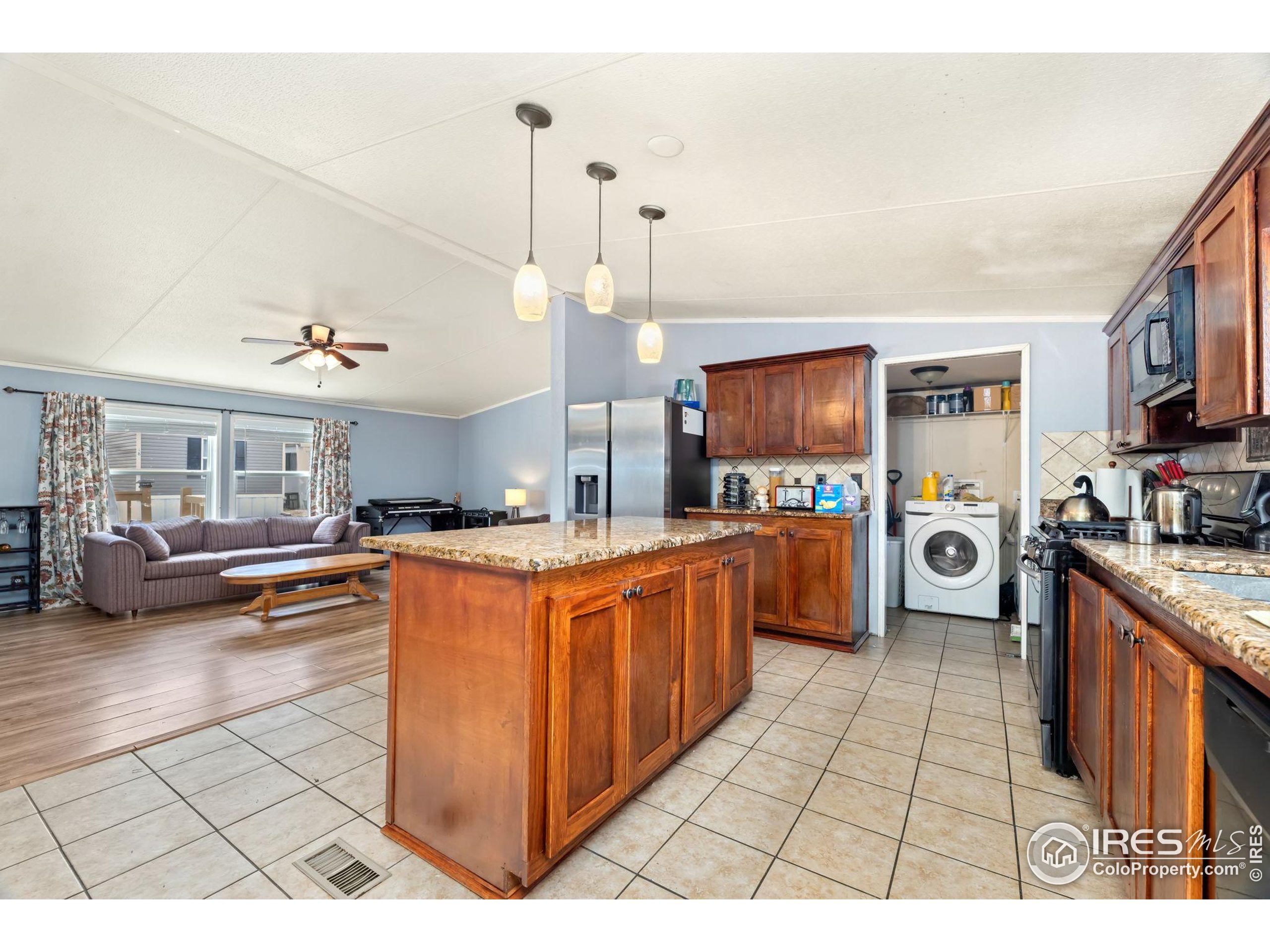 218 Grape Street, Unit 29 Hudson, CO 80642 - Photo 10 of 26 a large kitchen with stainless steel appliances granite countertop a stove a sink dishwasher and a wooden cabinets