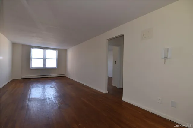 a view of a room with wooden floor and window