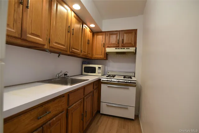a kitchen with stainless steel appliances granite countertop a sink stove and cabinets