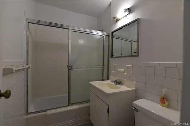 a bathroom with a shower a sink a toilet and mirror