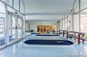 a living room with furniture a large window and wooden floor