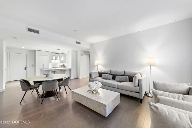 a living room with furniture a table and kitchen view