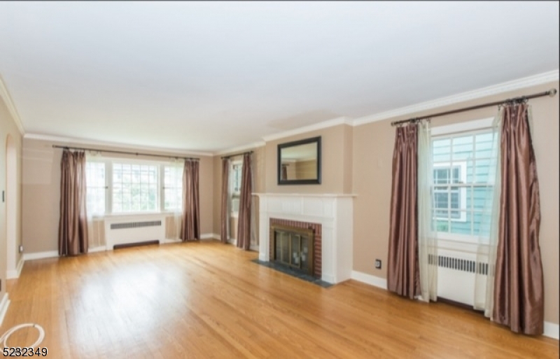 17 Bailey Road Millburn, NJ 07041 - Photo 4 of 24 an empty room with wooden floor fireplace and windows