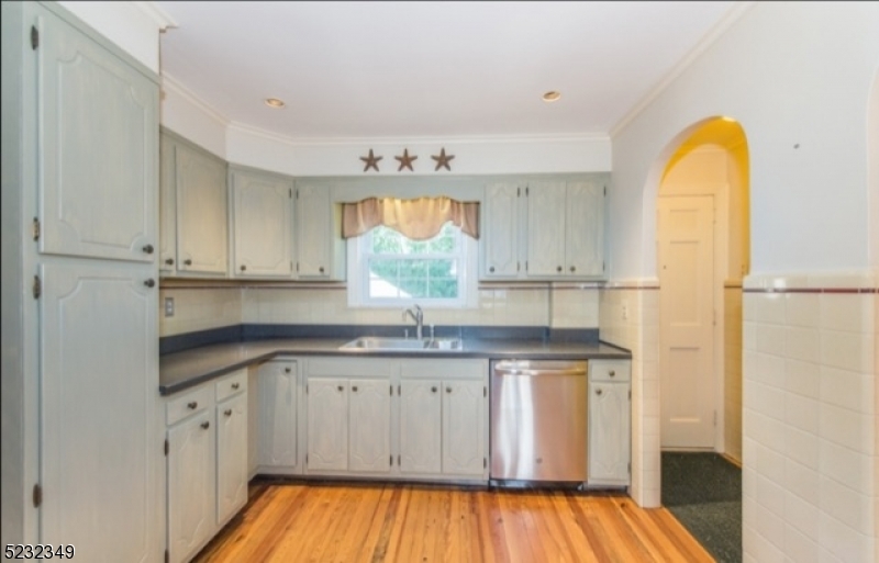 17 Bailey Road Millburn, NJ 07041 - Photo 10 of 24 a kitchen with granite countertop white cabinets and wooden floor